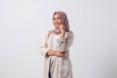 Téléchargez les photos : Portrait de femme hijab asiatique attrayante en costume décontracté se sentant confiant, posant avec geste professionnel de la main. Isolé sur fond blanc - en image libre de droit