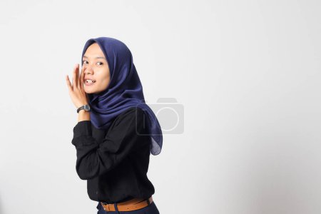 Portrait of excited Asian hijab woman in casual suit screaming announcement and whispering gossip. Businesswoman concept. Isolated image on white background