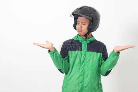 Téléchargez les photos : Portrait de chauffeur de taxi en ligne asiatique portant une veste verte et un casque au choix entre 2 options différentes, tenant deux mains avec un espace vide. Image isolée sur fond blanc - en image libre de droit