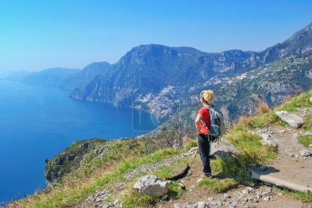 Wanderin beobachtet wunderschöne Küstenlandschaft - Götterpfad "Sentiero degli Dei" der berühmte Küstenwanderweg, Amalfiküste, Italien