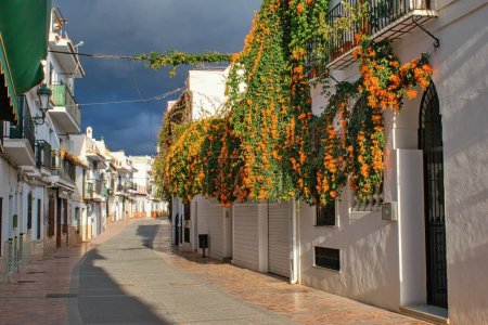 Strassen- und Blumenschmuck (Flammenrebe) dekorierte Häuser der Stadt Nerja - Andalusien, Spanien