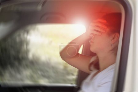 Photo floue d'une femme assise dans la voiture souffrant de vertiges ou de vertiges ou d'un autre problème de santé du cerveau ou de l'oreille interne.