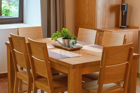 Foto de Muebles de cocina de madera maciza. Mesa y sillas, acogedor interior del hogar. - Imagen libre de derechos