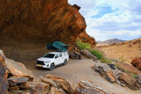 Téléchargez les photos : Voiture hors route avec tente sur le toit dans le camping sauvage. Namibie road trip. - en image libre de droit