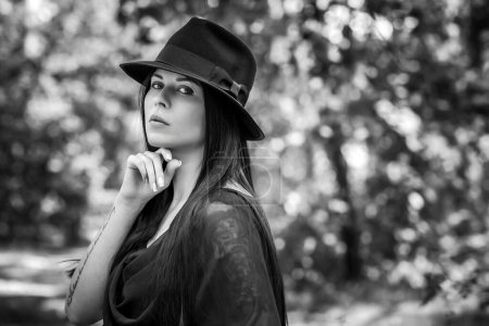 Téléchargez les photos : Femme aux cheveux longs foncés de style gothique noir, robe noire. Mystérieux portrait en forêt - en image libre de droit