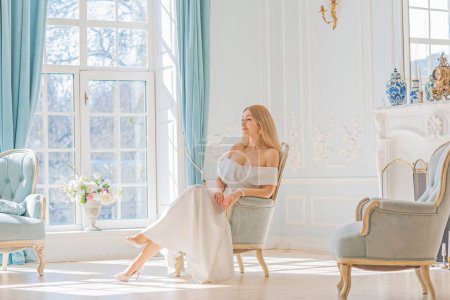 Romantic old money style. Woman wear white midi dress on royal light blue background, fashionable scene. Concept of vintage luxury lifestyle.