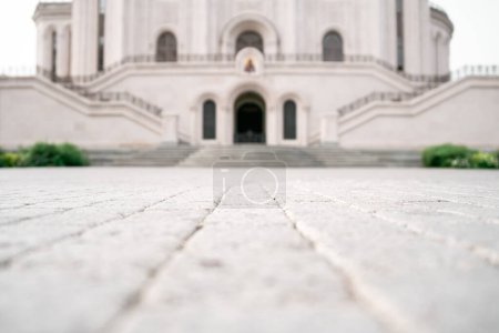Photo for Selective focus. The path along the paving stones to the stairs and blurred doors to the church above which the icon hangs. - Royalty Free Image