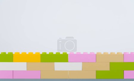 Colorful plastic bricks wall on white background.