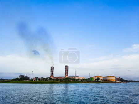 Hohe Umweltverschmutzung durch Kraftwerke. Kraftwerk an der Küste. Ökologisches Katastrophenkonzept. Kraftwerk hohe Rohre mit schwarzem Rauch, der die Atmosphäre verschmutzt.
