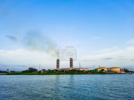 High pollution from power plant. Power plant on the coast. Ecology disaster concept. Power plant high pipes with black smoke moving up polluting atmosphere.