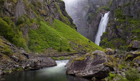Foto de Una cascada en una montaña con un puente sobre ella - Imagen libre de derechos