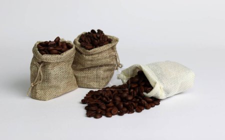 Téléchargez les photos : Grains de café en sacs de toile de jute sur un fond blanc. Image en gros plan avec grains de café. - en image libre de droit