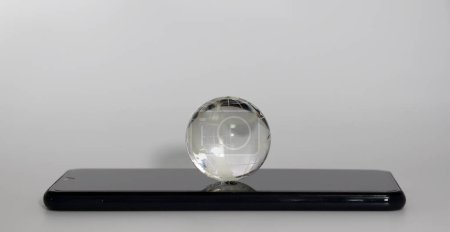 Téléchargez les photos : Un globe sur un smartphone. Concept de connexion numérique de terre. - en image libre de droit