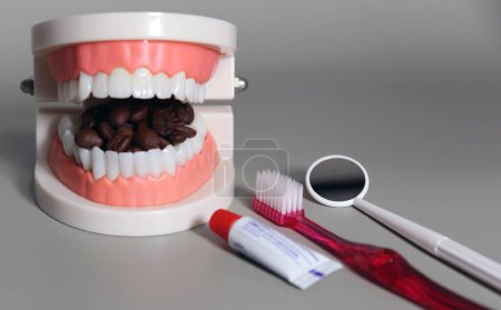 Les grains de café et les outils de soins dentaires qui remplissent votre bouche. Concept de boisson dentaire malsaine.