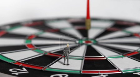 The red dart arrow in the middle of the dart paper is the goal of the business. An entrepreneur looking at arrows on a dartboard. Concept of business marketing plans and objectives. 