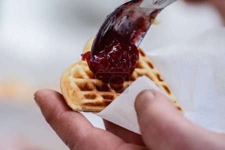 Photo for Preparing waffle or waffles with jam, dish made from leavened butter or dough that is cooked between two plates that are patterned to give a characteristic size, shape, and surface impression - Royalty Free Image