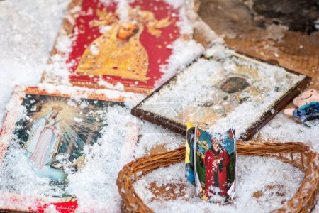 Foto de Vilna, Lituania - 4 de marzo de 2023: Santas imágenes iconográficas de los santos y de la Virgen María cubiertos por la nieve durante una nevada en un frío día de invierno - Imagen libre de derechos