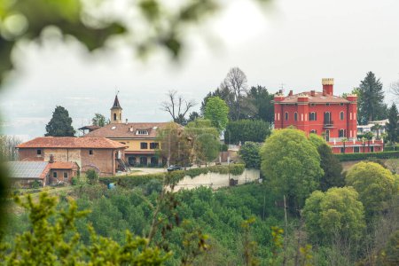 Photo for Panoramic view of the hills with green vegetation and a red castle or building from San Sebastiano da Po Castle, Torino, Piemonte region, Italy - Royalty Free Image