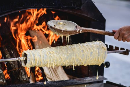 Initial stage of preparation of a tree cake, Lithuanian akotis, Polish skacz, Belarusian bankucha, German baumkuchen made of butter, egg whites and yolks, flour, sugar, cooked over an open fire