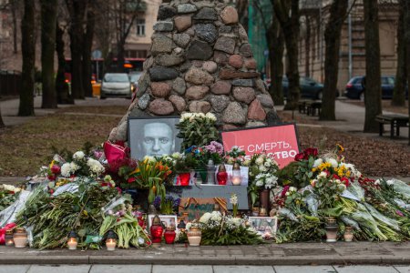 Téléchargez les photos : Vilnius, Lituanie - 21 février 2024 : Fleurs et bougies posées au mémorial spontané de Vilnius pour le chef de l'opposition russe Alexei Navalny, avec des portraits et des messages laissés par les gens - en image libre de droit