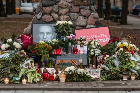 Téléchargez les photos : Vilnius, Lituanie - 21 février 2024 : Fleurs et bougies posées au mémorial spontané de Vilnius pour le chef de l'opposition russe Alexei Navalny, avec des portraits et des messages laissés par les gens - en image libre de droit