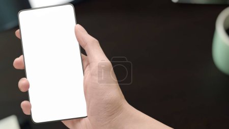 Photo for Selective focus close-up image of male hands using modern smartphone device in office table top perspective, reading social media sms message and checking e-mail. Product staging screen space mock-up. - Royalty Free Image