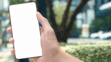 Photo for Selective focus close-up image of male hands using modern smartphone device in urban city park street, reading social networks app sms message and checking e-mail. Product staging screen space mock-up - Royalty Free Image
