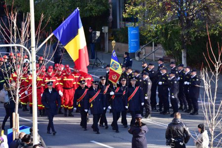 Foto de El desfile nacional de día en Targu-jiu con bomberos equipados con uniformes, trajes de protección y vehículos especiales de bomberos rojos - Imagen libre de derechos