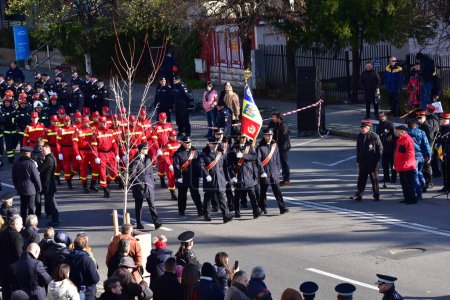 Foto de El desfile nacional de día en Targu-jiu con bomberos equipados con uniformes, trajes de protección y vehículos especiales de bomberos rojos - Imagen libre de derechos
