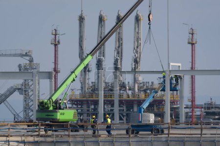 Foto de SWINOUJSCIE, POMERANIA Occidental - POLONIA - 2022: Trabajadores y maquinaria de construcción en una terminal de gas - Imagen libre de derechos