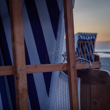 Téléchargez les photos : PLAGE DE LA MER - Des paniers de plage au lever du soleil attendent les baigneurs - en image libre de droit