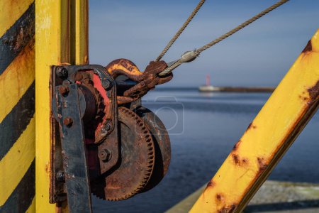 MARITIME TRANSPORT - Yellow manual crane on the seaport quay