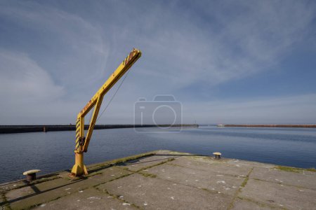MARITIME TRANSPORT - Yellow manual crane on the seaport quay