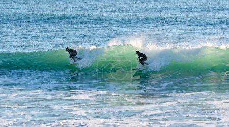 Foto de Dos surfistas comparten una linda ola en la costa atlántica del sur de España en Cádiz - Imagen libre de derechos