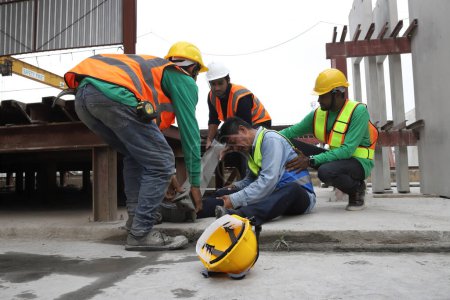Foto de Accident at work of construction worker at site. Safety team helps employee accident. - Imagen libre de derechos