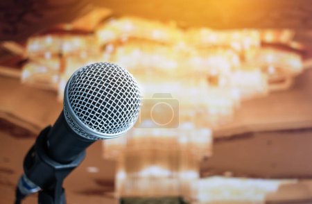 Téléchargez les photos : Gros plan du microphone dans le séminaire de conférence pour discours ou salle de concert avec fond de lumière floue événement - en image libre de droit