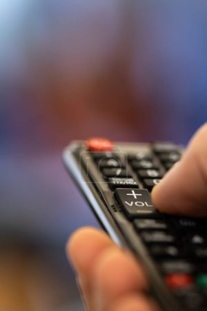 Photo for Change programs on tv with the remote control. binge watching, choose streaming series on smart tv. remote control to switch movies on tv - Royalty Free Image