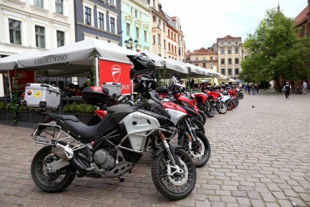 Photo for Torun, Poland - May 7, 2022:  Ducati motorcycles near a restaurant on the square nearl Town Hall and square in the Old Town of Torun, - Royalty Free Image