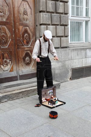 Photo for Torun, Poland - May 7, 2022:  A street performer delights people strolling along the street with a music and puppet performance - Royalty Free Image