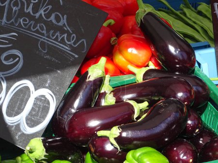 Photo for Fresh eggplants and tomatoes on display at a farmers market. - Royalty Free Image
