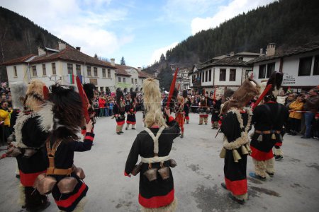 Téléchargez les photos : Shiroka laka, Bulgarie - 5 mars 2023 : Des gens avec un masque appelé danse Kukeri et se produisent pour effrayer les esprits maléfiques au Festival des Jeux de la Mascarade "Pesponedelnik" à Shiroka laka, Bulgarie. - en image libre de droit