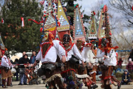 Téléchargez les photos : Elin Pelin, Bulgarie - 11 mars 2023 : Festival de mascarade à Elin Pelin, Bulgarie. Les gens avec un masque appelé danse Kukeri et effectuer pour effrayer les esprits maléfiques. - en image libre de droit