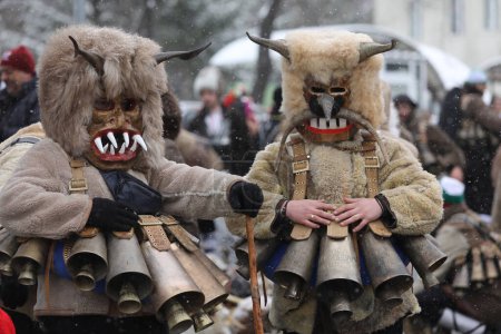 Téléchargez les photos : Breznik, Bulgarie - 20 janvier 2024 : Des personnes non identifiées avec le costume traditionnel Kukeri sont vues au Festival des Jeux de la Mascarade Surova à Breznik, Bulgarie. - en image libre de droit