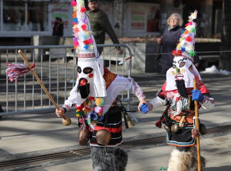 Téléchargez les photos : Pernik, Bulgarie - 26 janvier 2024 : Festival international de mascarade Surva à Pernik, Bulgarie. Les gens avec un masque appelé danse Kukeri et effectuer pour effrayer les esprits maléfiques. - en image libre de droit