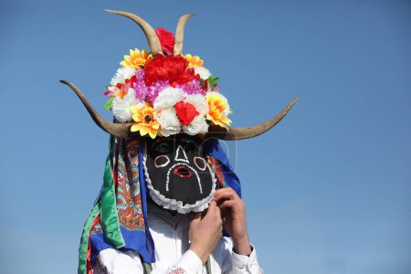 Téléchargez les photos : Elin Pelin, Bulgarie - 17 février 2024 : Festival de mascarade à Elin Pelin, Bulgarie. Les gens avec un masque appelé danse Kukeri et effectuer pour effrayer les esprits maléfiques. - en image libre de droit