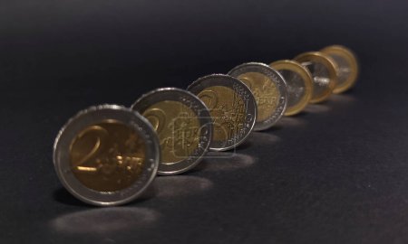 Blick auf Euromünzen auf dunklem Hintergrund, Fokus auf die mittlere Münze