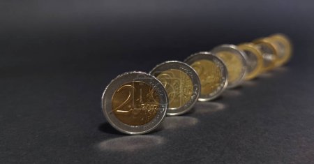 Blick auf Euro-Münzen auf dunklem Hintergrund, Fokus auf Vordermünze