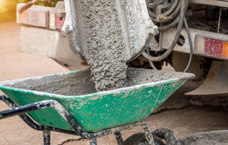 Téléchargez les photos : Mélange de béton service de camion coulant du ciment dans la construction du site le jour. Le ciment a été versé dans un fauteuil roulant ou un chariot de ciment pour faire le plancher - en image libre de droit
