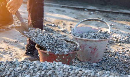 Téléchargez les photos : Les ouvriers ramassaient des pierres avec une houe dans les seaux - en image libre de droit