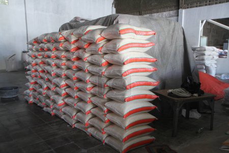 Foto de Pila sacos de cáñamo de arroz. Montón de sacos de arroz en almacén de grano - Imagen libre de derechos